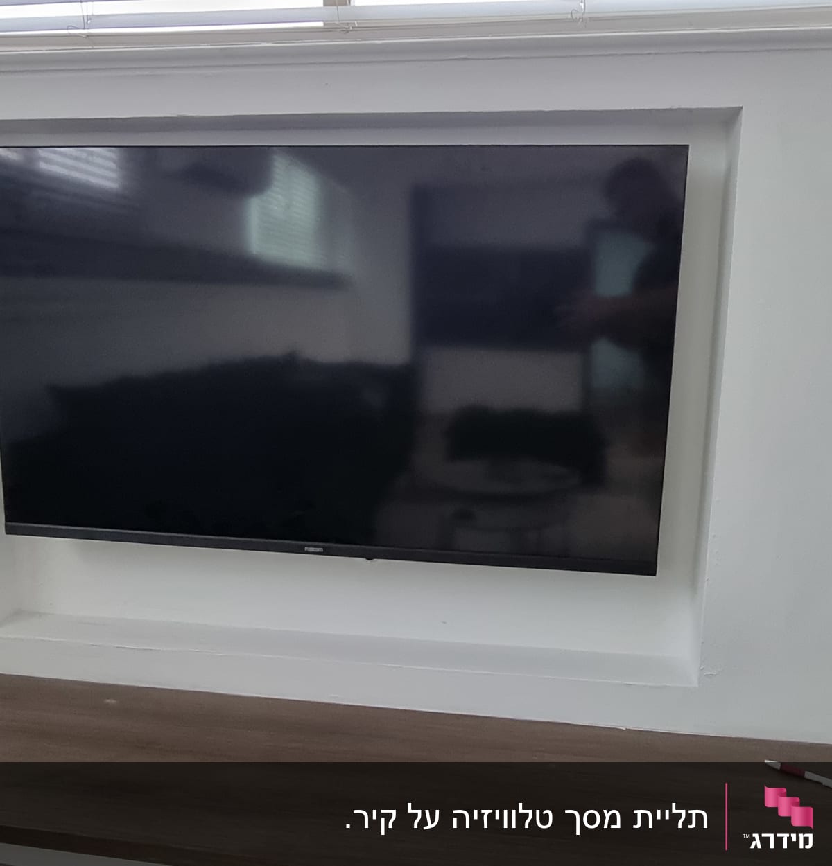 טלוויזיה מותקנת על הקיר עם מתקן תלייה